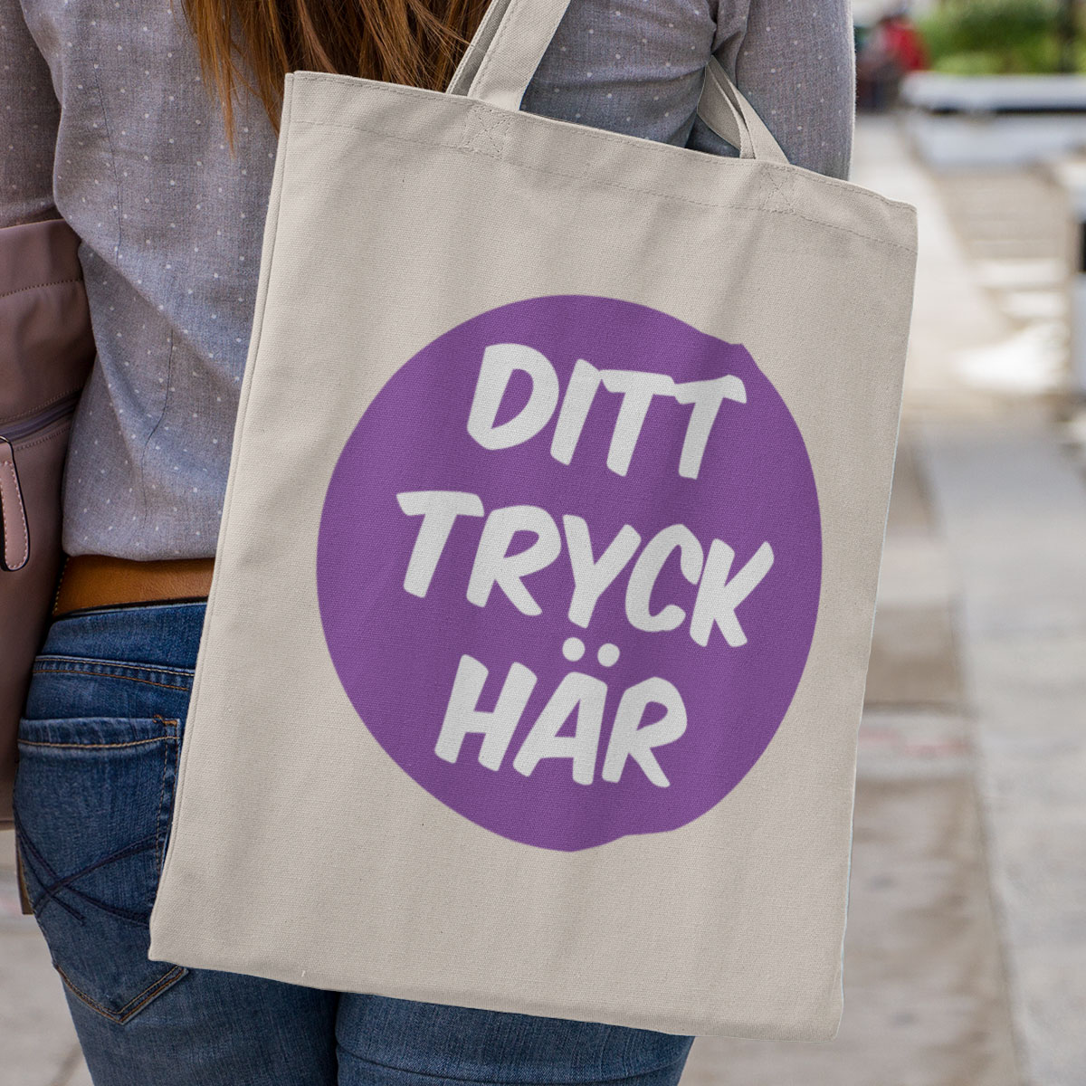 Kvinna bär en egendesignad tygväska över axeln